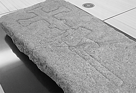 Lauda sepulcral de un carnicero, con el relieve del hacha y una cruz, procedente de San Bartolomé o Vello de Pontevedra, siglos XV-XVI. Museo Provincial de Pontevedra.